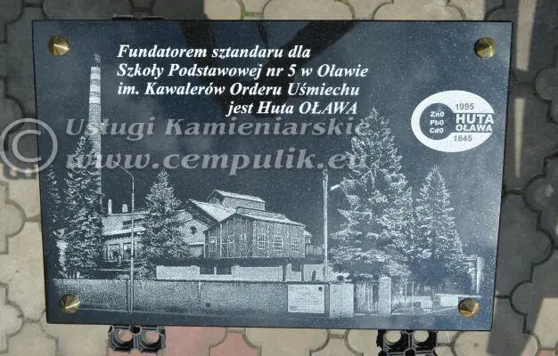  Huta Oława	Tablica pamiątkowa z grawerem i napisem: Fundatorem sztandaru dla Szkoły Podstawowej nr 5 w Oławie im. Kawalerów Orderu Uśmiechu jest Huta Oława.
                                    